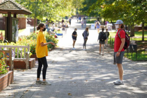 Eagles Cares Ambassador Abby Zimmerman chats with a fellow student on Campus Walk. These student volunteers ensure that others are following the University's "MMDC" - monitor, mask, distance and clean - policy. Photo by Suzanne Carr Rossi.