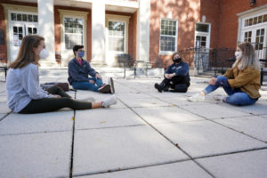 From left to right: sophomore Megan Giglio and juniors David Miller, Kira Frazee and Alison Bliss enjoy the fall weather while chatting on the Lee Hall plaza. Photo by Suzanne Carr Rossi.