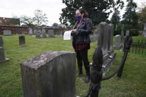 Senior Brianna Melick leads a Graves and Ghouls tour of the City Cemetery, where more than 3,300 dead Fredericksburg residents have been buried. This image shows off the ornate "corn-cob" fence around one plot. Photo by Suzanne Carr Rossi.