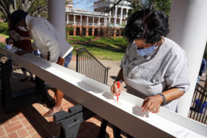 Fredericksburg City Schools Superintendent Marci Catlett, a founder of UMW's James Farmer Scholars program and former adjunct professor, signs her name to a beam that was placed atop Seacobeck. Photo by Suzanne Carr Rossi.