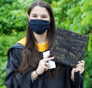 Stephanie Johnson holds up her mortarboard that her kindergarten students signed for her graduation ceremony, where she received an M.S. in elementary education from UMW. Photo by Suzanne Carr Rossi.