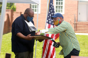 Delegate Joshua Cole (right) presents Chris Williams with House Resolution 601, commending his work with the JFMC to keep Dr. Farmer's legacy alive. Photo by Karen Pearlman.