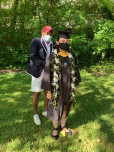 Dean of Students Cedric Rucker makes regalia tweaks for environmental science major Gabi Radoiu '20.