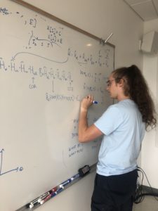 Junior Drake Richmond solves equations for research on the interplay of interactions in molecular dynamics with Assistant Professor of Physics Varun Makhija.