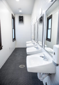 Glistening hall bathrooms replaced the old suite-style versions during Virginia Hall's renovation. Floor-to-ceiling showers lend privacy for first-year students who will call the residence hall home. Photo by Tom Rothenberg.