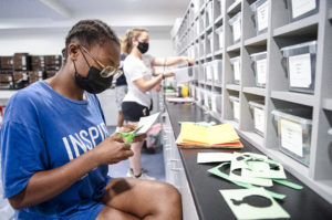 UMW students Noell Evans (front) and Addie Sage (back) create school-spirit-promoting decorations in the basement of the newly renovated Virginia Hall. The room for resident assistants, and their projects and supplies, was freshened up during the 14-month construction period. Photo by Tom Rothenberg.