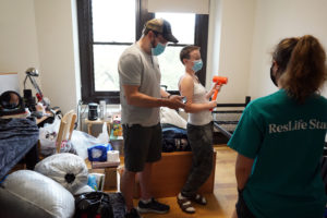 UMW first-year student Robbie Willcox holds the orange mallet she used to wrangle her bed in the newly renovated Virginia Hall. Assembling residence hall loft beds comes with its challenges. Photo by Suzanne Carr Rossi.