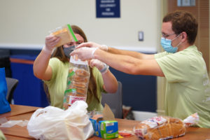 From left to right, Kendall Resnick and Eli Keith pack sandwiches to be distributed to Fredericksburg's homeless residents. Photo by Suzanne Carr Rossi.