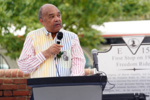 Freedom Rider Dion Diamond speaks to the crowd gathered for the unveiling of the marker, while wearing his mug shot from the Freedom Rides pinned to his shirt. He spent two years participating in the protests to desegregate interstate travel. Photo by Suzanne Carr Rossi.