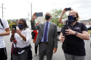 James Farmer Multicultural Center Director Marion Sanford (left) and UMW President Troy Paino (center) snap photos at the ceremony to unveil the permanent marker commemorating the first stop of the 1961 Freedom Rides. Photo by Suzanne Carr Rossi.