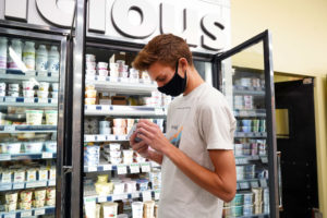 Dustin Jenkins checks a yogurt for its expiration date. Photo by Suzanne Carr Rossi.