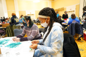 Eliana Nachman (left) and Shae Cummings make teal ribbons for Rappahannock Council Against Sexual Assault. Photo by Suzanne Carr Rossi.