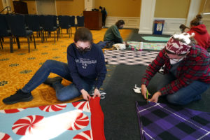 Kaylee Deardorff (left) and Cosette Veeder-Shave make blankets for local schoolchildren. Photo by Suzanne Carr Rossi.