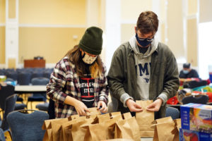 Chenin Guber (left) and AJ Gluchowski make bagged lunches for Micah Hospitality Center as part of Saturday's MLK Day of Service. Photo by Suzanne Carr Rossi.