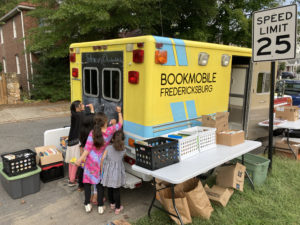 Children draw on the chalkboard door on the back of the Bookmobile. Cobb said he wanted kids to feel welcome to explore the ambulance-turned-mobile library as they search for books.