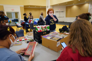 McDaid, who serves as the associate director of Bookmobile Fredericksburg, helps UMW students sort books at the MLK Day of Service earlier this year. Photo by Suzanne Carr Rossi.