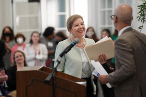 UMW President Troy Paino gives the podium to Virginia Secretary of Education Aimee Rogstad Guidera at yesterday's ribbon-cutting ceremony recognizing the official opening of Seacobeck Hall as the new home to the College of Education. Photo by Suzanne Carr Rossi.