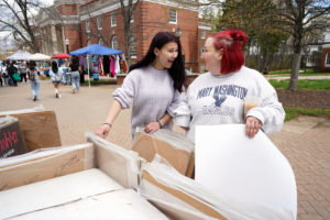 UMW students Bailey Merriman (left) and Megan Childs (right) look over posters to buy at the fair. Photo by Suzanne Carr Rossi.