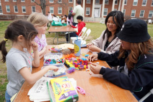 Hazel Lam-Mackintosh and Harper Thaden (left) make bead bracelets with UMW students Jenny Vuong and Boramy Meng. Photo by Suzanne Carr Rossi.