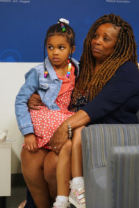 Vicki Jones-Whitties, Dr. Jones' sister, sits with her granddaughter, listening to the speeches made in honor of the late physician and Mary Washington alumna. Photo by Suzanne Carr Rossi.