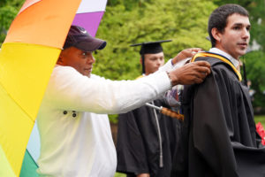 Dean of Student Life Cedric Rucker (left) helps make sure Cody Hill looks just right before the graduates process. Rucker, who has been an integral part of Mary Washington students' lives for decades, will retire next month. Photo by Suzanne Carr Rossi.