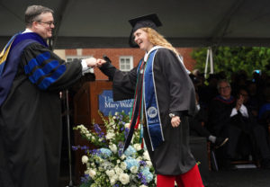 Interim Provost Tim O'Donnell exchanges a fist bump with a new UMW graduate. Photo by Suzanne Carr Rossi.