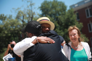 Rucker hugs former SGA President Jason Ford '20, who spoke during Sunday's celebration, while Fredericksburg Mayor Mary Katherine Greenlaw looks on. Photo by Karen Pearlman.