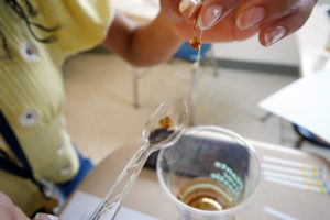 Students in the Summer Enrichment Program's Kitchen Chemistry course use syringes, chemical test strips, calcium chloride and Coke to make bobas. Photo by Suzanne Carr Rossi.