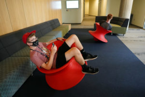 Xander Kent, a rising senior at Riverbend High School, twirls in a red spinny chair while capturing the action on a 360 camera. The footage was used to explore the dynamics of augmented and virtual reality. Photo by Suzanne Carr Rossi.