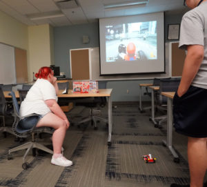 UMW student Megan Childs, who served as one of several Summer Enrichment Program counselors, watches while a camper participates in a session about virtual and augmented reality. Photo by Suzanne Carr Rossi.