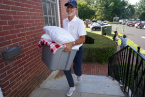 President Troy Paino pitched in to help haul belongings into Westmoreland Hall. Paino and wife Kelly chatted with students and parents on move-in day, and offered practical help as well. Photo by Suzanne Carr Rossi.