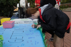 UMW student Ava Barsotti signs a banner before heading out to complete one of several group projects at last weekend's Into the Streets event. Photo by Nathan Francis.