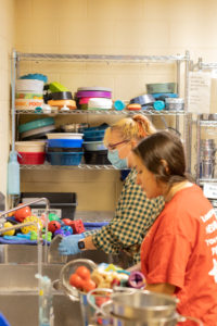 UMW students Jillian Vargas and Willow Candage volunteer at the Fredericksburg SPCA as part of Into the Streets. Photo by Nathan Francis.