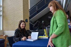 Hauser signs copies of her books for participants of last week's colloquium. Photo by Brolin Creative.