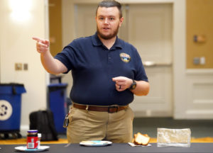 Michael Darnell, an engineer from the Naval Surface Warfare Center Dahlgren Division, acts as the "Mike-bot." Students "programmed" him to make a peanut butter and jelly sandwich. The exercise illustrates the thought process of robot-programming engineers who condense instructions into bite-sized commands. Photo by Suzanne Carr Rossi.