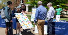 Two men admire a poster adorned with colorful sticky notes representing community values