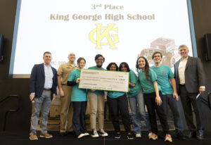 Naval Surface Warfare Center Dahlgren Division’s Technical Director Dale Sisson Jr., SES, and Commanding Officer Captain Philip Mlynarski, along with University of Mary Washington’s Dr. John Burrow (left), pose with the King George High School’s (KGHS) robotics team who placed third in Innovation Challenge @ Dahlgren. KGHS was able to field two teams for the event. (U.S. Navy photo/Released)