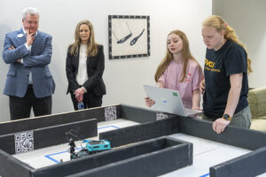 Dean of the University of Mary Washington’s College of Business Ken Machande and Naval Surface Warfare Center Chief Technology Officer Jennifer Clift observe as the Northern Neck Regional Technical Center robotics team tests their robot on a practice course in preparation for the competition phase of the second annual High School Innovation Challenge @ Dahlgren. (U.S. Navy photo/Released)