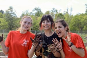 From left to right, UMW students Camille Lamey, Brooke Abrash and Gabriela Valle show off the effects of their participation in a gardening community service project during Engagement Day. Photo by Kaira Otero.
