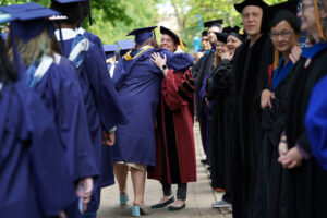 Faculty members line up on either side of Campus Walk to cheer on the graduates. Photo by Suzanne Carr Rossi.