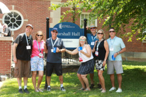 Mary Washington graduates pose in front of the Marshall Hall sign. Housing thousands of students since the 1960s, Marshall and neighboring Russell Hall are slated to come down to make way for the new home of UMW's Department of Theatre and Dance. Photo by Karen Pearlman Photography.