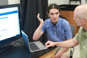 UMW junior Carter Bussey (left) talks with Professor of Physics Matthew Fleenor during the Summer Science Institute. With Fleenor's guidance, Bussey used the 10-week program to explore exoplanets (planets that exist outside of our solar system) using Skynet telescopes. Photo by Karen Pearlman.