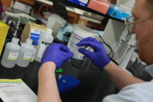 Miles prepares a solution for use in his research during this year's Summer Science Institute, a program that encourages close collaboration between students and faculty. Photo by Karen Pearlman.