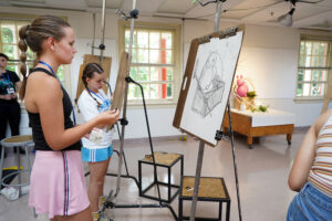 Keira Walsh (foreground) and Sarah Skeeters complete an assignment in Assistant Professor of Painting and Drawing Ashe Laughlin's "Exploring Art and Practice" course, one of 17 offered to high-schoolers who participated in UMW's Summer Enrichment Program. Photo by Suzanne Carr Rossi.