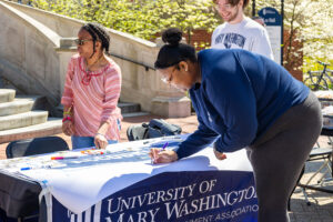 UMW seniorJaylyn Long signs a banner during last year's ASPIRE week. The series of events recognizing UMW values was created by Long. Photo by Sam Cahill.
