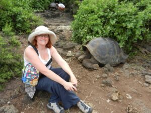 Sally Brannan Hurt ’92 with a giant tortoise in the Galápagos Islands on a Mary Washington Alumni on the Road trip in 2011. The experience led her to establish the Sally Brannan Hurt '92 Study Abroad Scholarship in Biology to support students going on faculty-led trips to the islands. Photo courtesy of Sally Brannan Hurt.