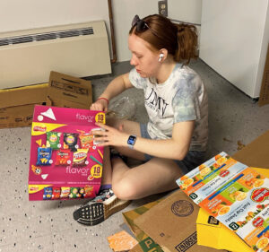 Junior Meghan McAndrew breaks down boxes in the Gwen Hale Resource Center, where she has worked as a volunteer and picked up items for herself. She has also helped friends find similar resources at their institutions. 
