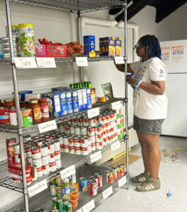 Tamara Garrett '23, an alum and AmeriCorps member, stocks shelves in the Gwen Hale Resource Center.