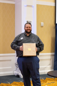 Assistant Director of Residence Life and Housing John Hughey poses after receiving an Atkins Award. Photo by Sam Cahill.