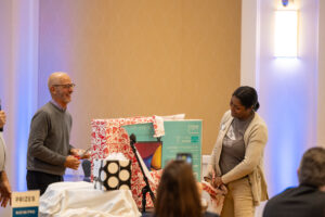 UMW President Troy Paino smiles as Simpson Library Office Manager Dee Chasten receives one of several door prizes given during the fall 2023 employee appreciation luncheon. Photo by Sam Cahill.